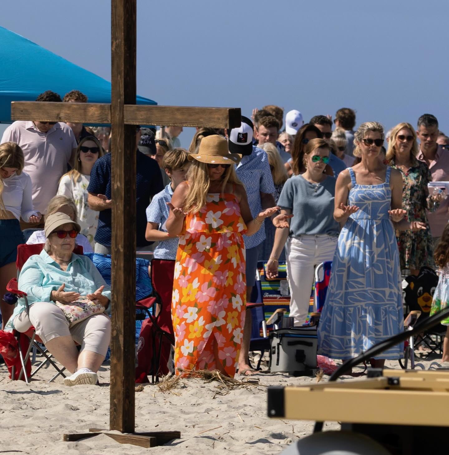 Congregation gathered on the beach around a wooden cross